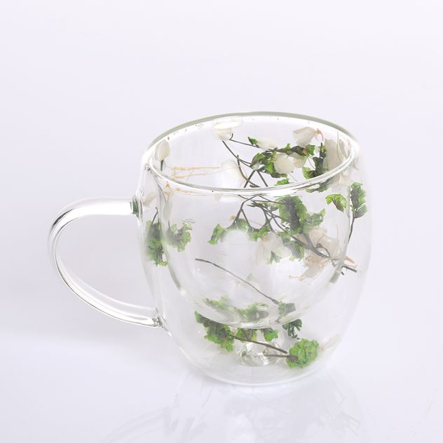 Cana din sticla transparenta cu flori verzi incapsulate